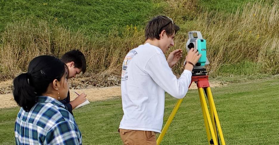 students using surveying equipment